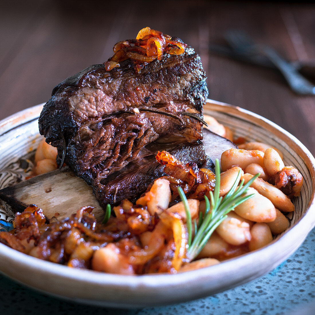 Slow cooked beef short rib with butterbean stew and caramelised onions