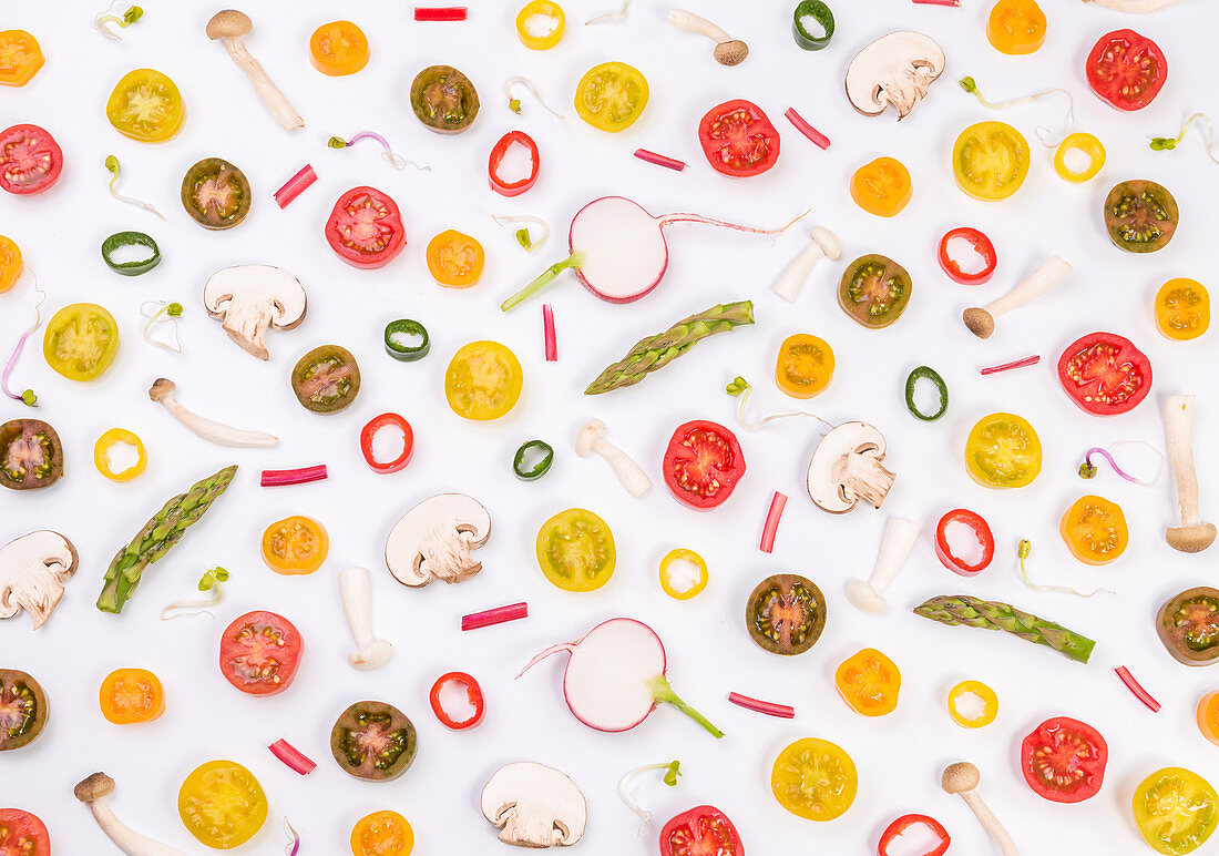 Tomatoes, mushroom, asparagus and pepper slices mixed on a white background