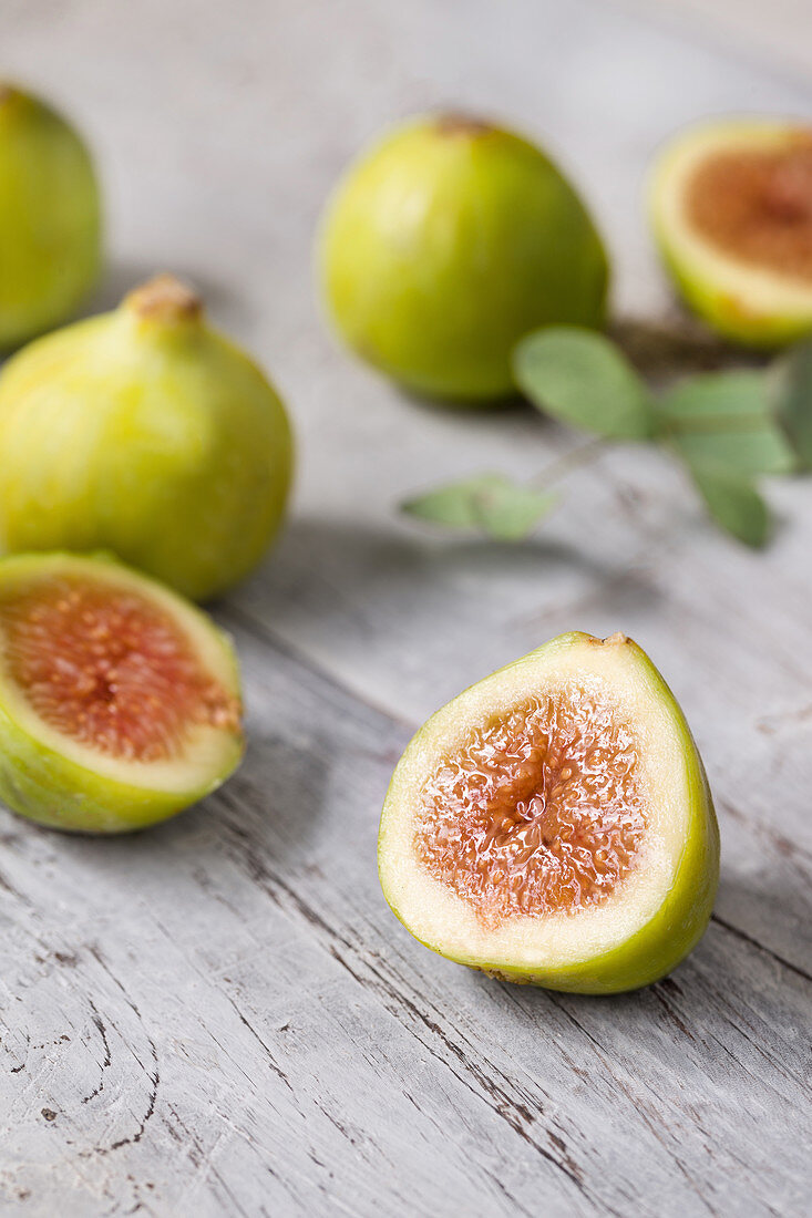 Green unripe fig fruit on wooden table