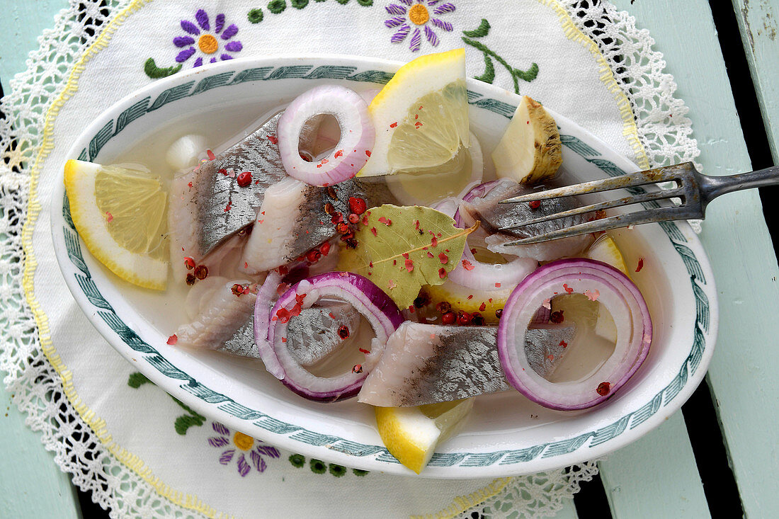 Pickled herring with red onions, bay leaves and lemon