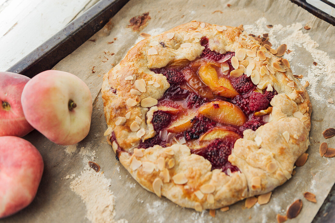 Galette with raspberries, peaches and flaked almonds