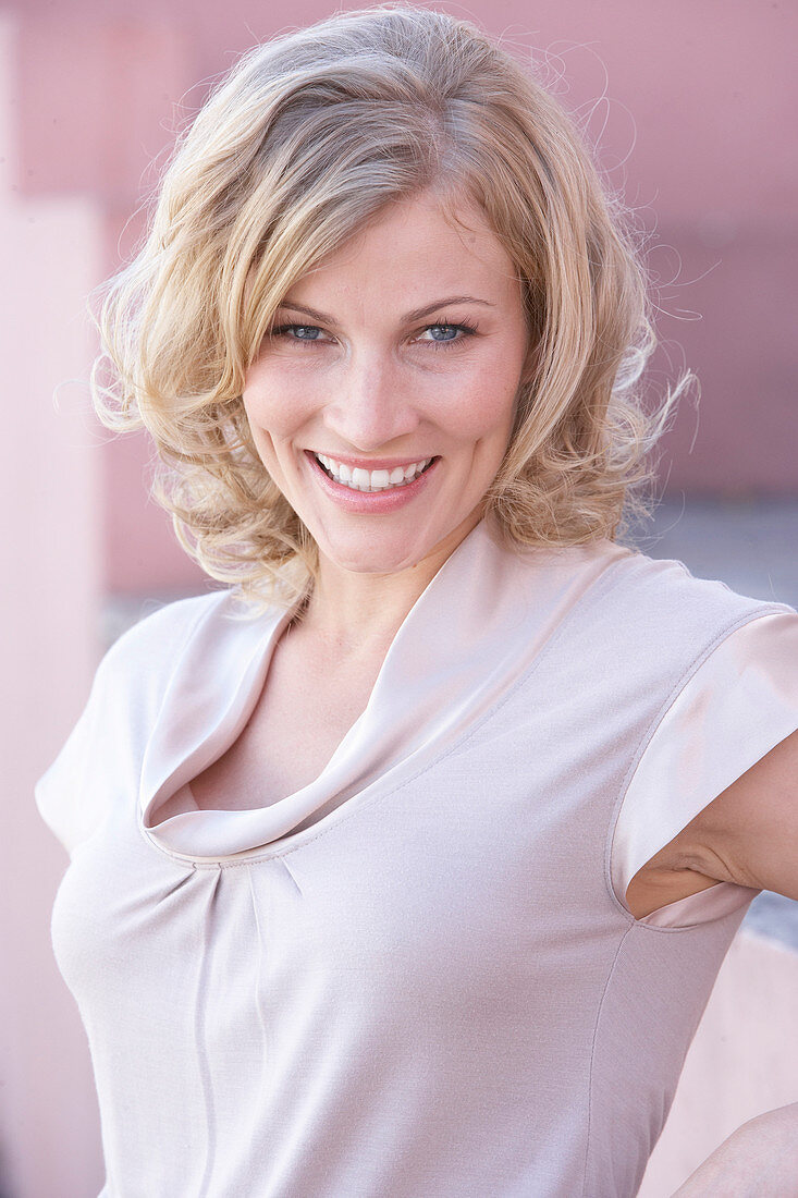 A blonde woman wearing a light blouse