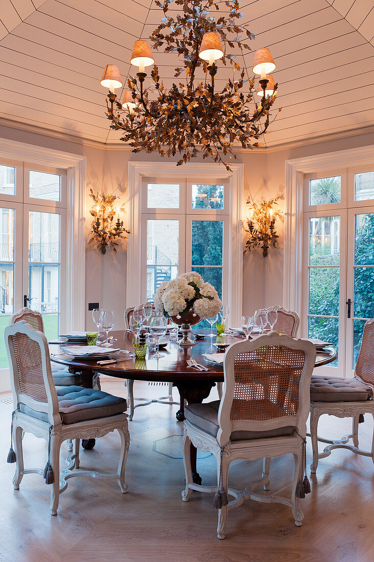 Circular laid Georgian table in octagonal pavilion with gilt Compiegne Leaf Chandelier and matching wall lights