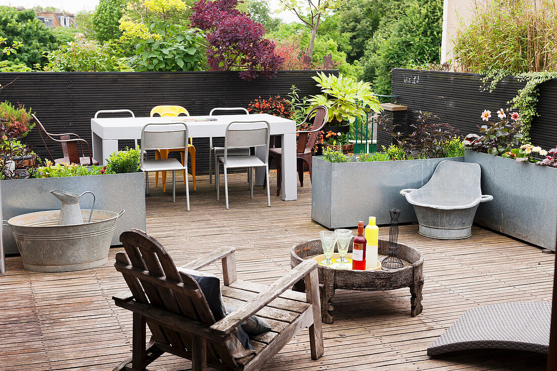 Wooden furniture, zinc tubs and dining table with chairs on wooden deck