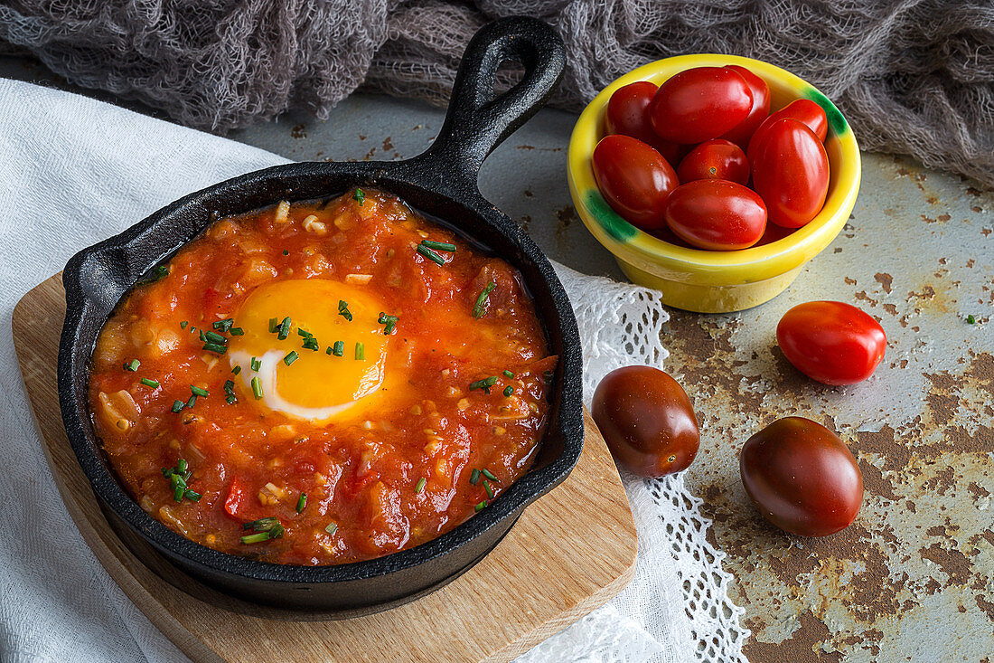 Spiegeleier mit Tomaten und Paprika in der Pfanne serviert (Spanien)