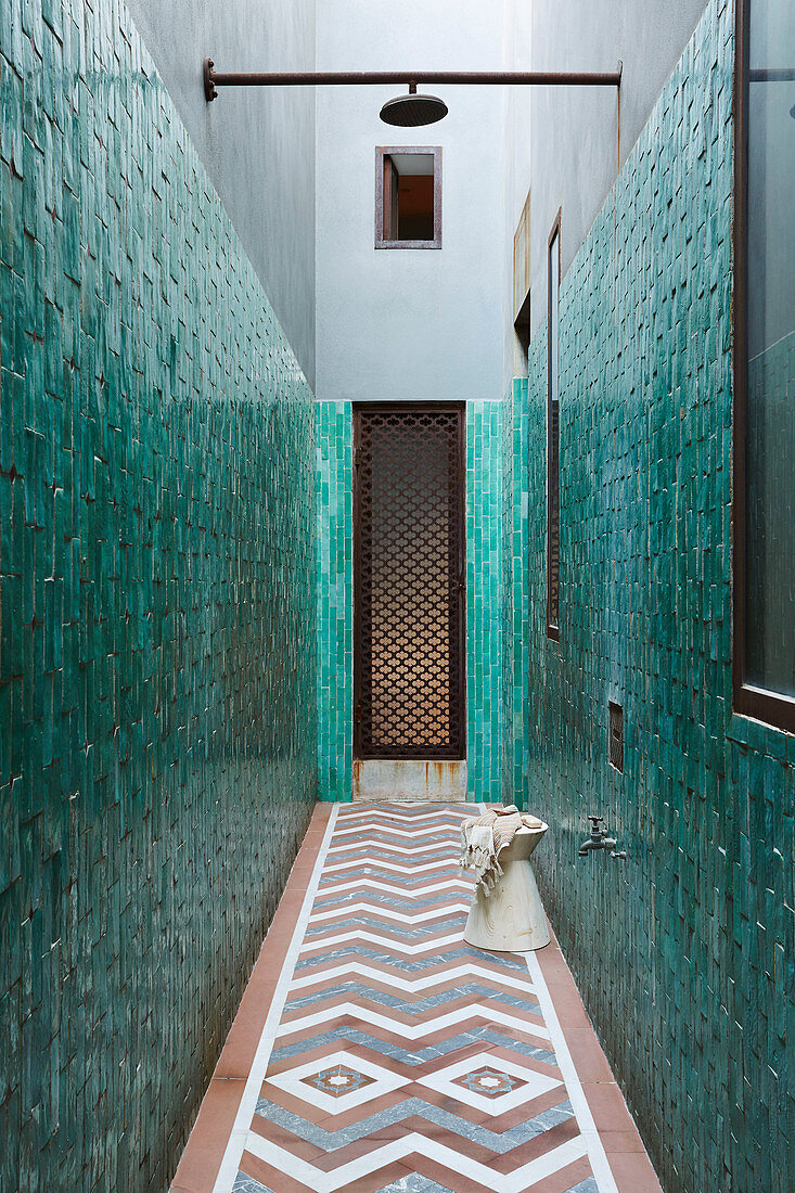 Outdoor shower in the narrow courtyard with tiled walls