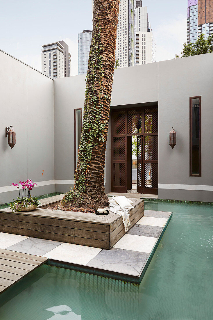 Island with palm tree in a courtyard pool