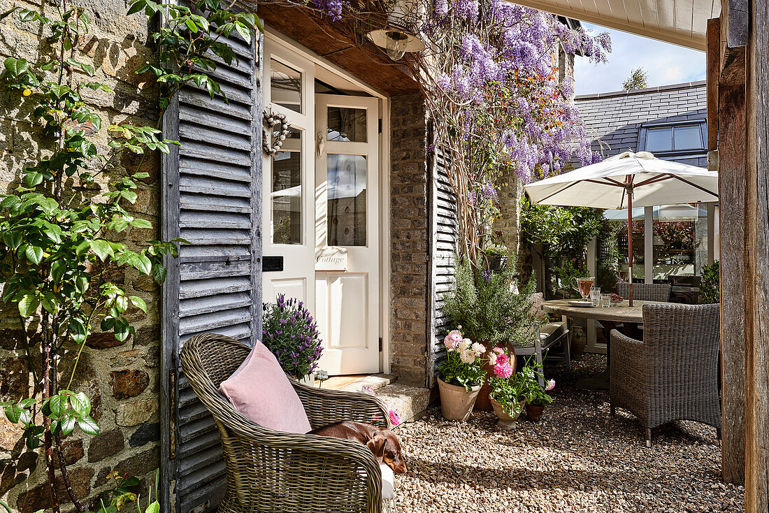 Rattansessel vor Vintage französischem Fensterladen auf Terrasse