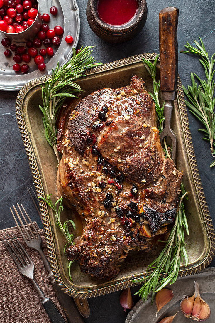 Whole baked beef with cranberry sauce and garlic above