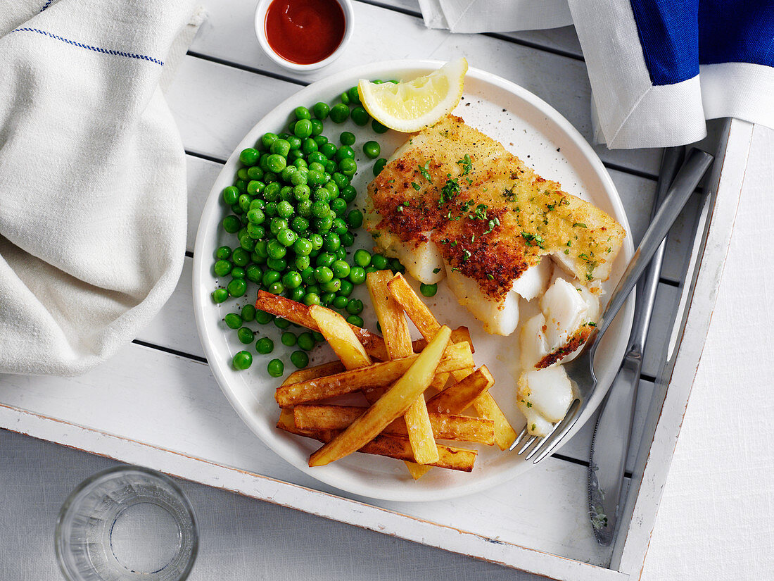 Herb topped fish and chips with peas
