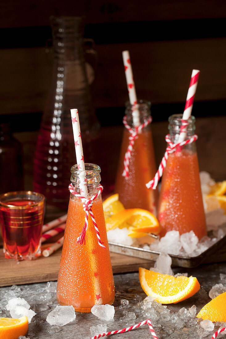 Bottles of Aperol Cocktails with Orange Wedges and Ice