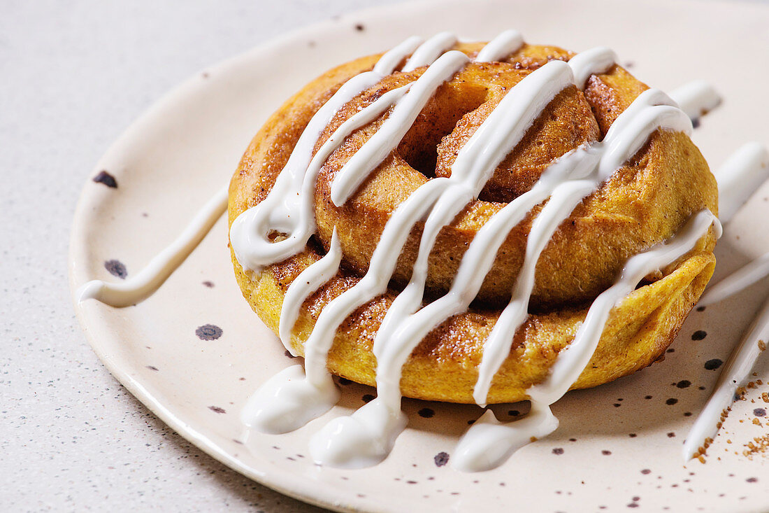 Homemade pumpkin cinnamon bun roll sweet autumn baked dessert with cream cheese sauce