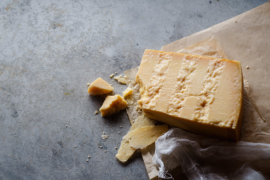 Ein Stück Parmesankäse auf Pergamentpapier