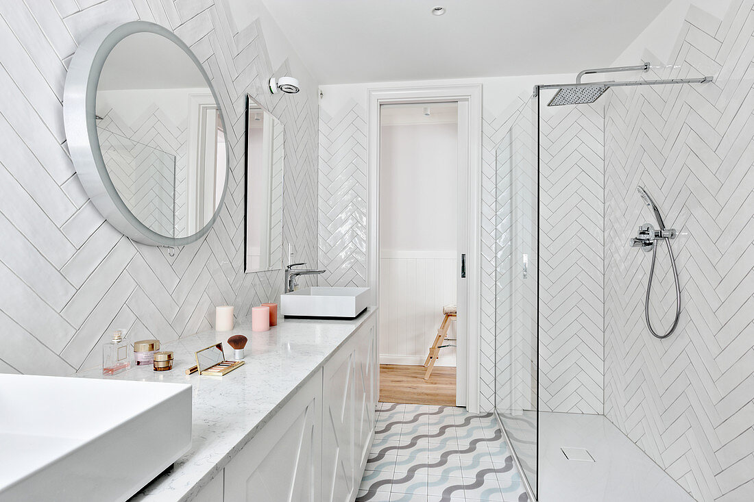 Tiles laid in herringbone pattern in white bathroom