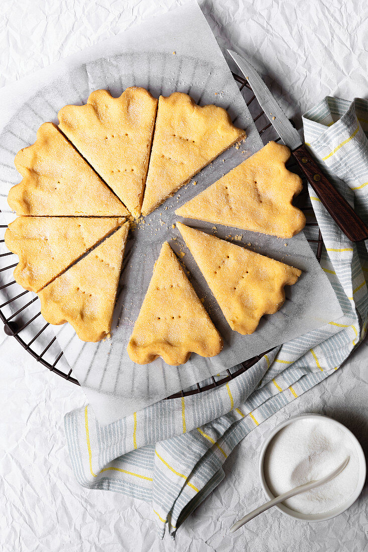 Homemade Scottish shortbread cut into wedges, cooling on a cake rack