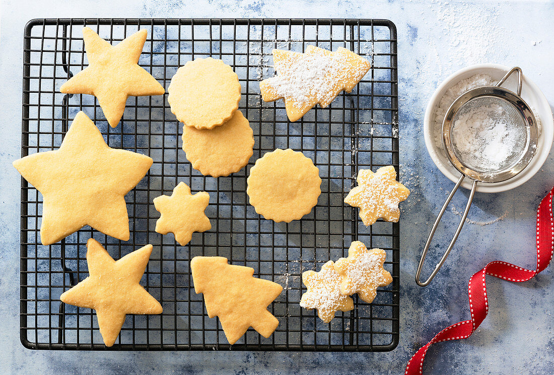 Different shaped Christmas Shortbread biscuits partially covered with icing sugar