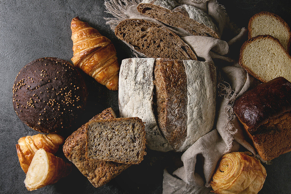 Variety of fresh baked rye, spelled, wheat craft artisan bread, whole and sliced