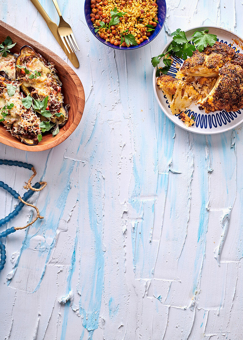 Cheesy mincestuffed aubergines, Spicy roasted cauliflower head with millet and chickpea salad