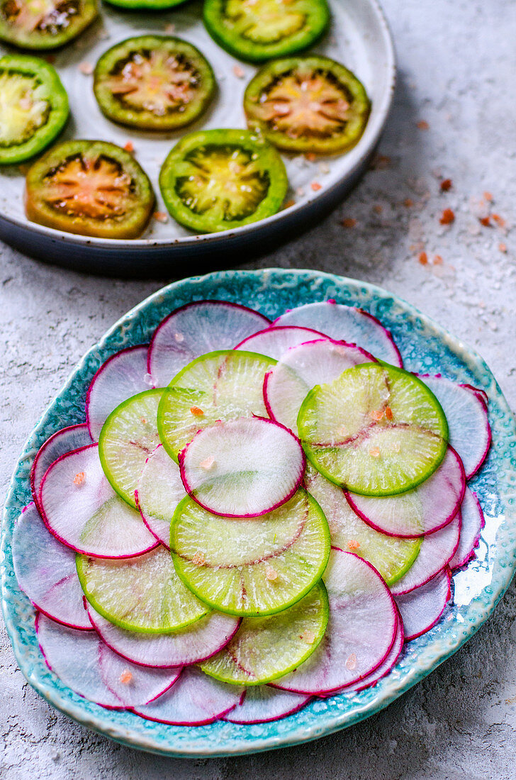 Slices of green and pink radishes and a ring of green tomatoes