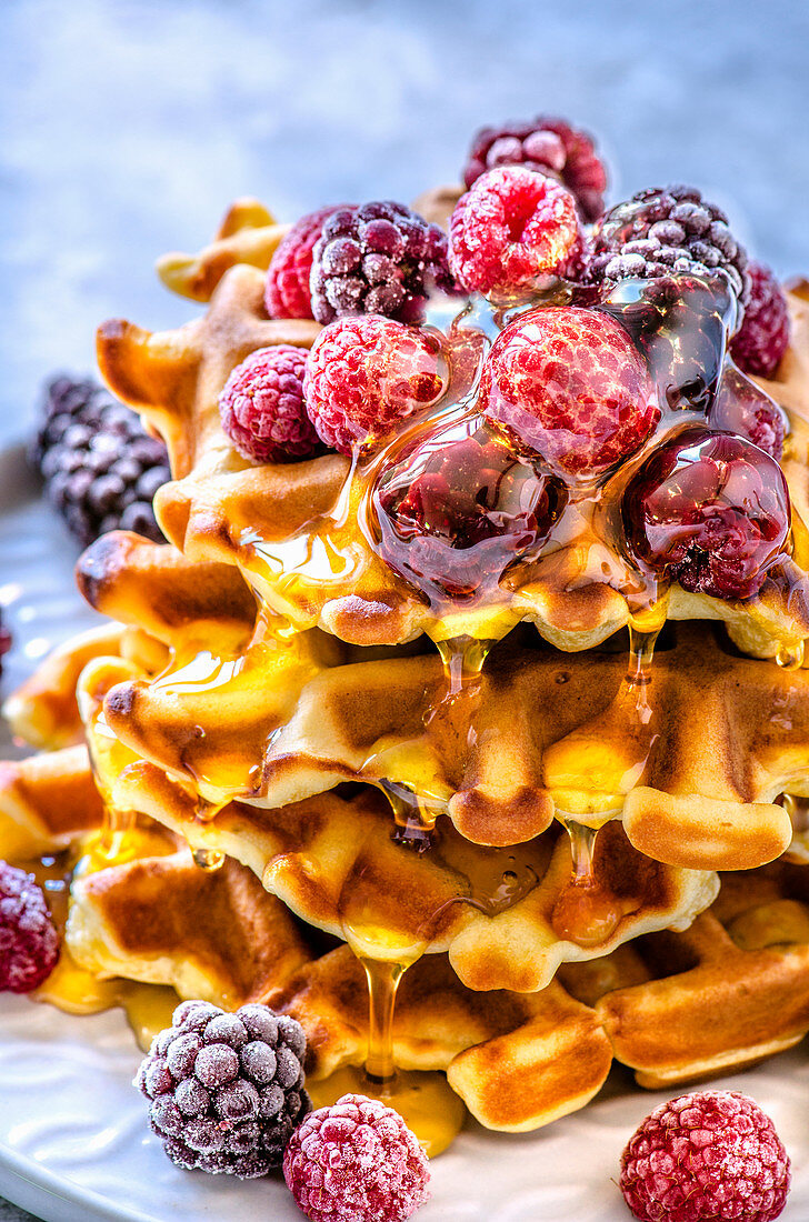 Home-made Belgian waffles baked in an electric waffle-iron with berries and maple syrup