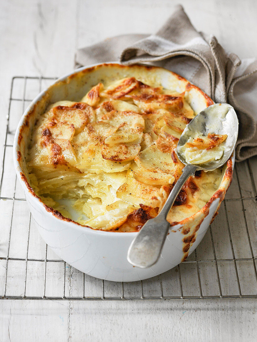 Gratin potato dauphinoise cut into to show cream and butter ingredients