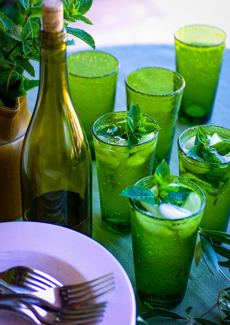 Eiswasser mit Minze in grünen Gläsern auf Tisch