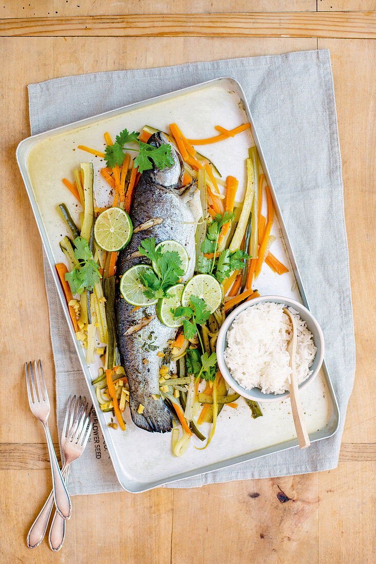 Asian trout with vegetables on a roasting tray