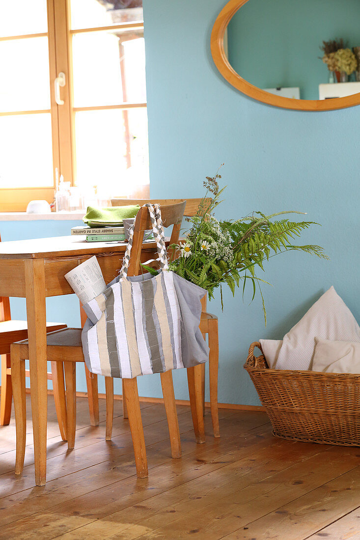 DIY linen bag decorated with fabric strips hung from kitchen chair