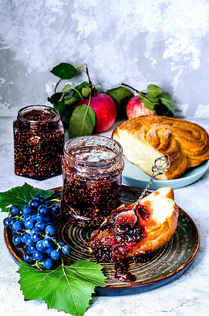 Grape and fig confiture, fresh blue grapes and bun with confiture