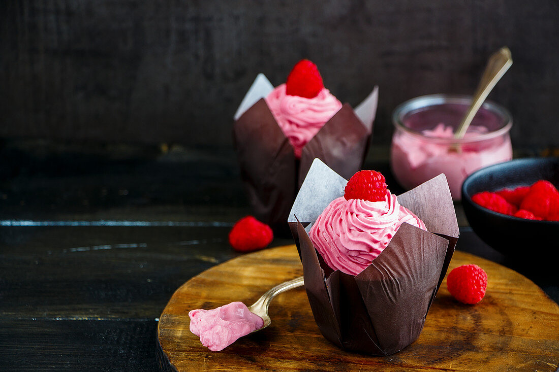 Cupcakes mit rosa Frischkäse und Himbeeren