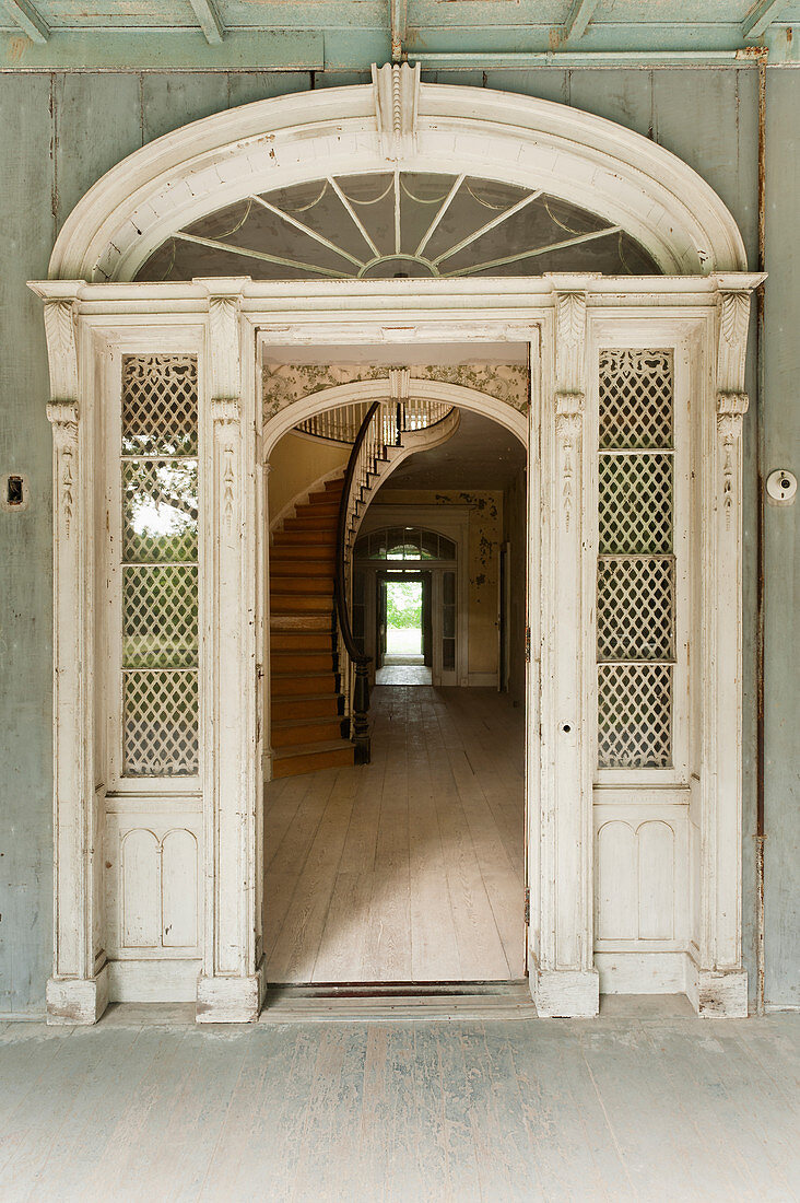 Old door with fanlight leading into old abandoned house