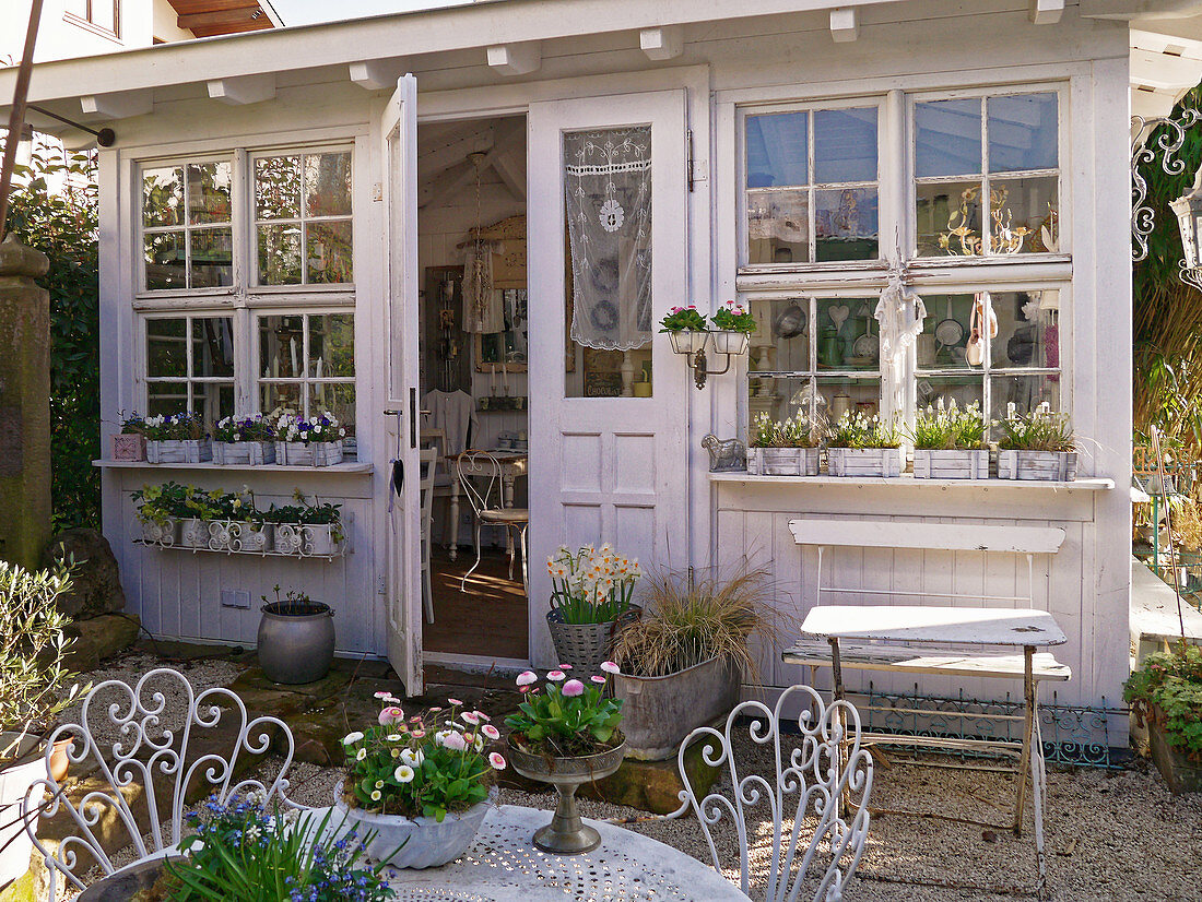 Kies - Terrasse mit Frühlingsblumen am Gartenhaus