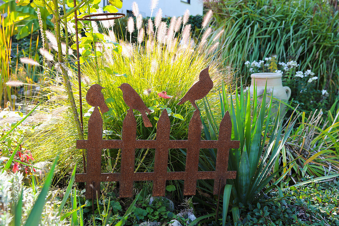 Spring bristle grass 'Hameln' behind deco rust made of rusty iron