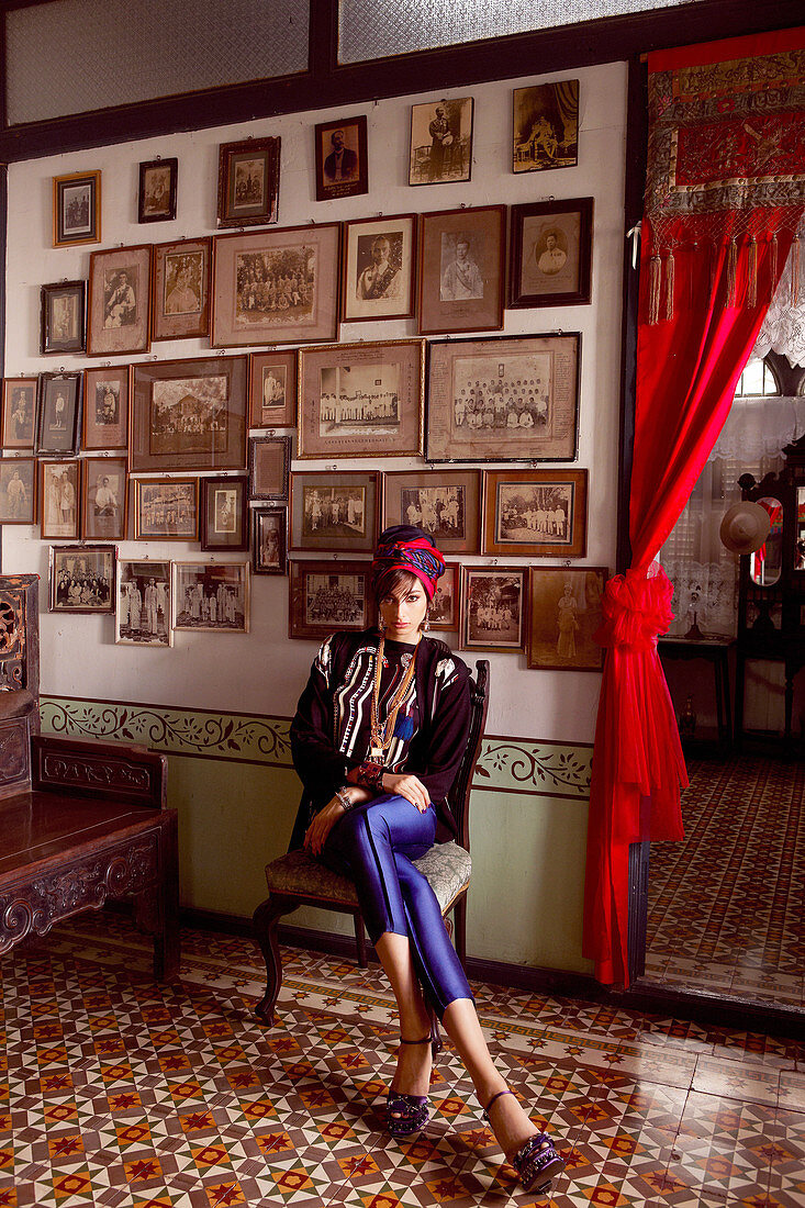 A young dark-haired woman wearing blue leggings, a jacket and headscarf