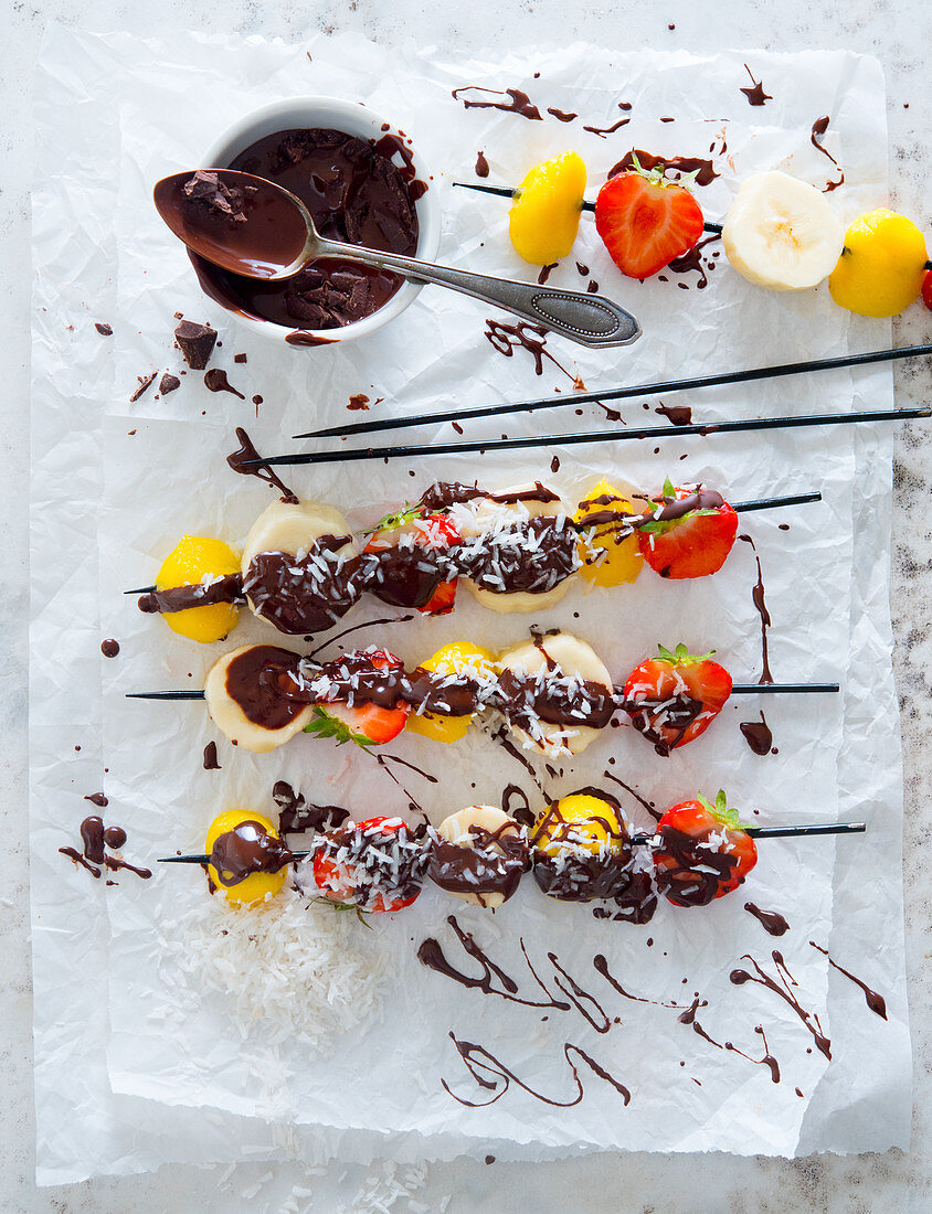 Fruit skewers with chocolate and grated coconut