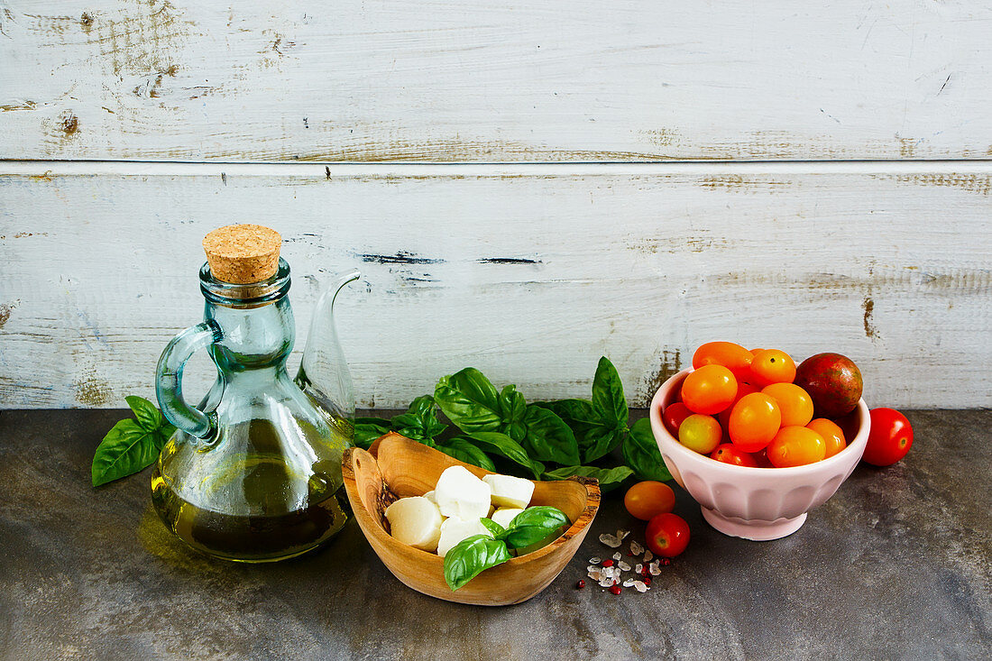 Tomato, mozzarella, basil leaves and olive oil for an Italian salad
