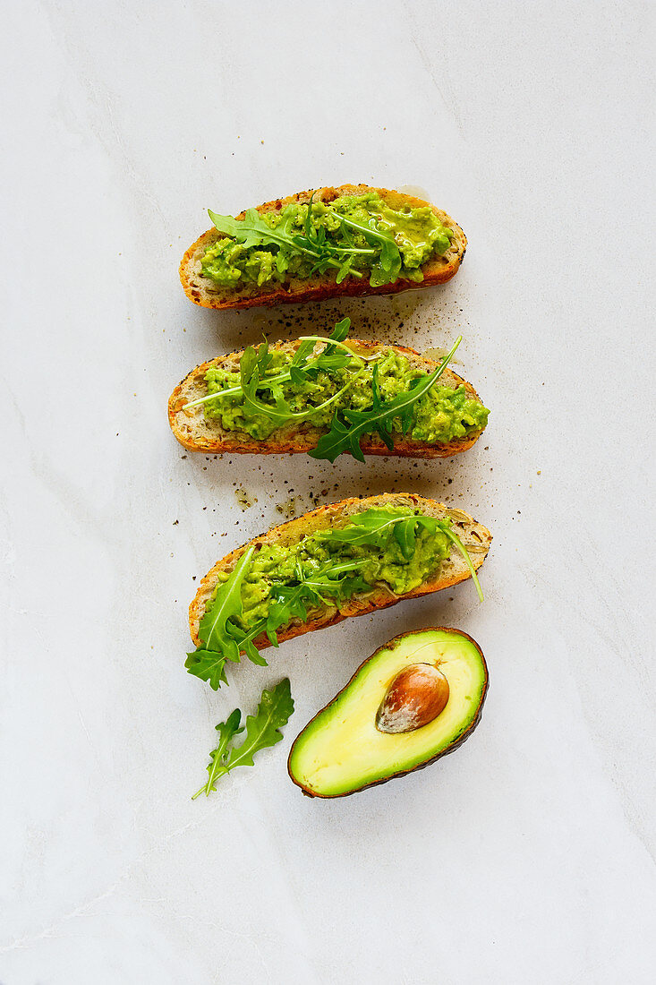 Homemade avocado toasts with arugula