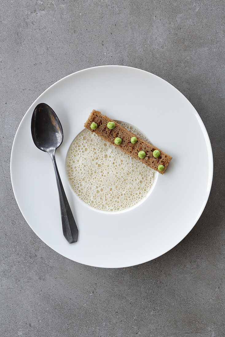 Chanterelle foam soup with a grilled bread stick