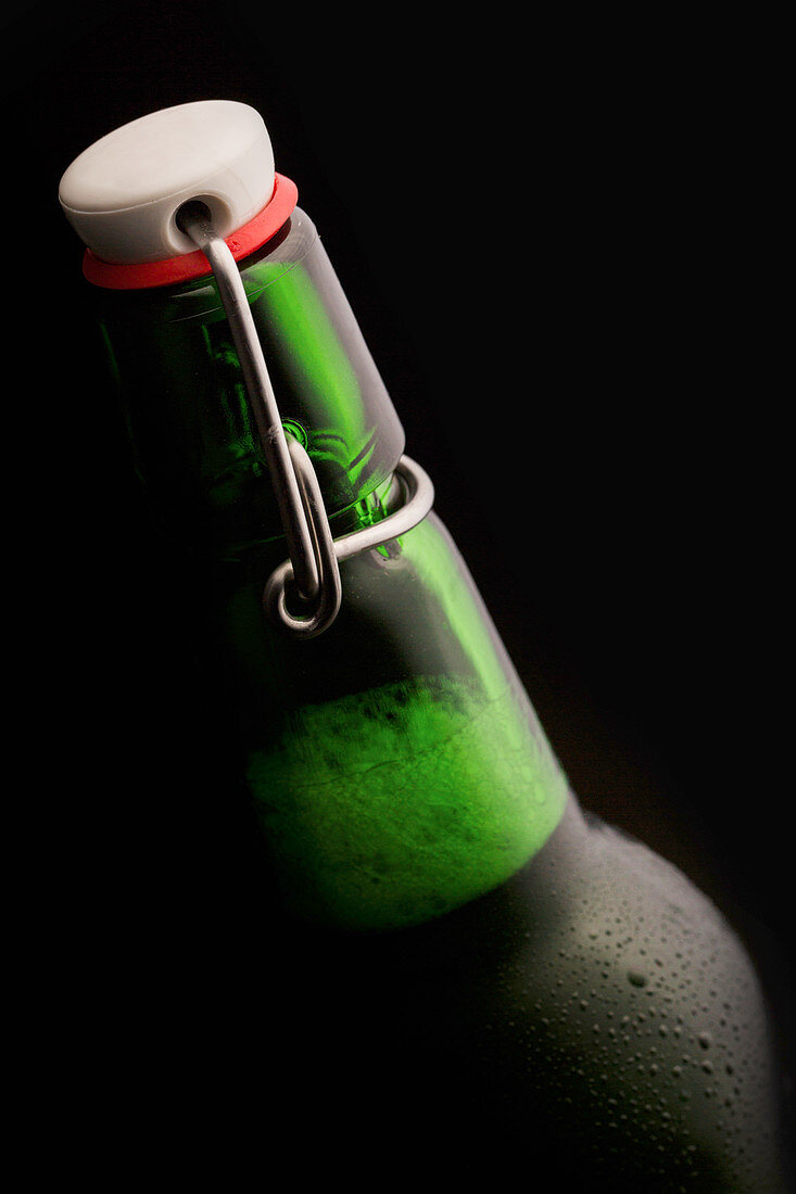 A bottle of beer against a black surface