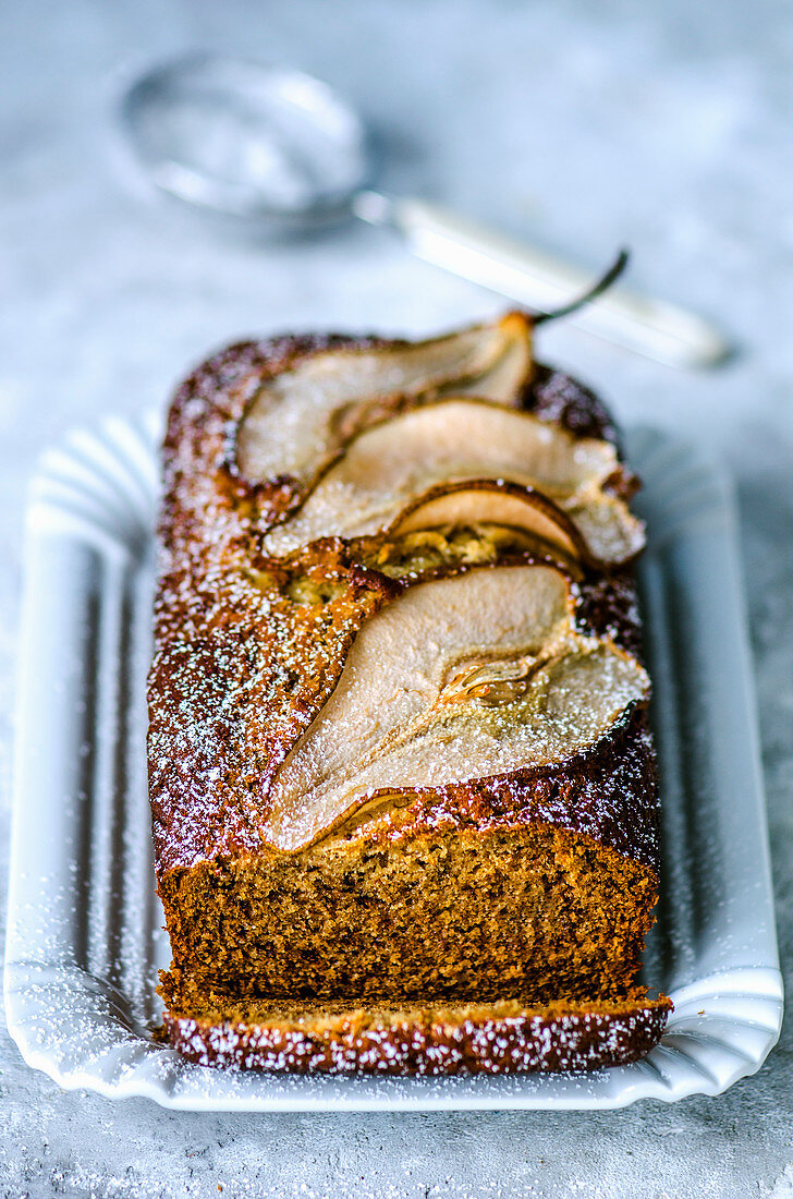 Banana muffin decorated with slices of pear in a white plate