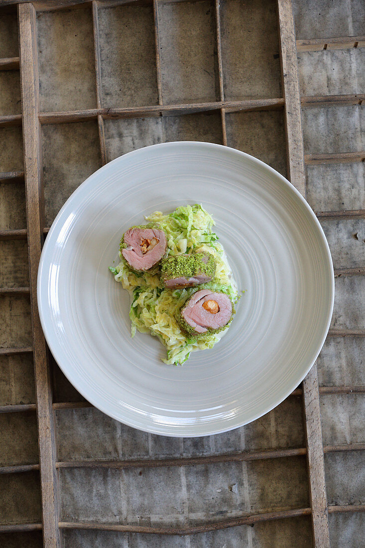 Stuffed pork fillet with a herb crust on a savoy cabbage medley