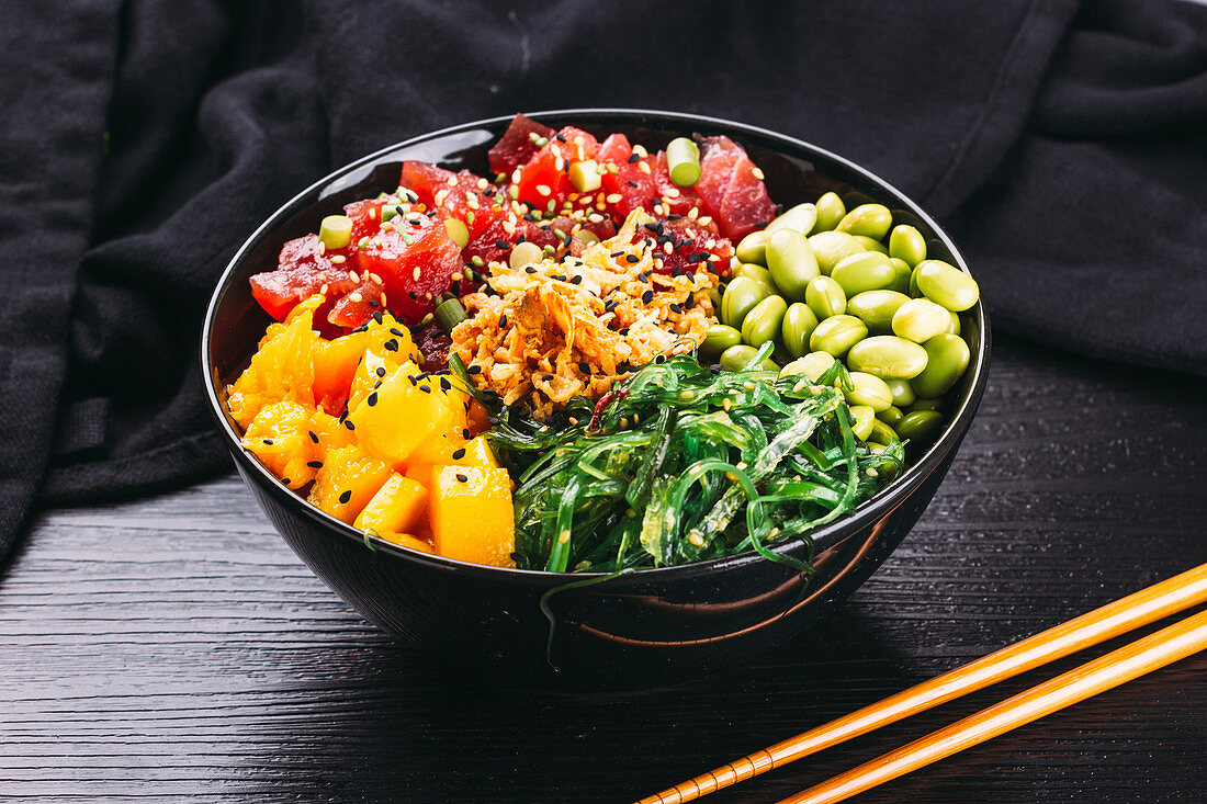 A poke bowl with tuna fish, mango, algae and edamame (Asia)