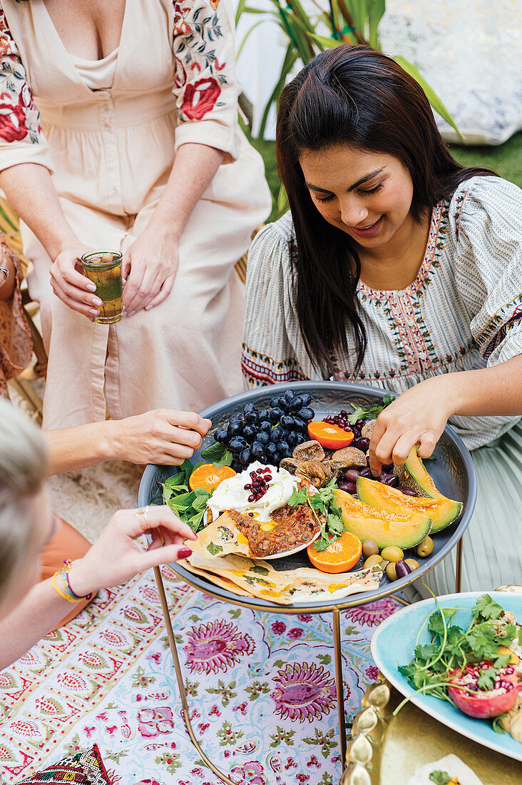 Girlfriends celebrating outdoors with Moroccan dishes