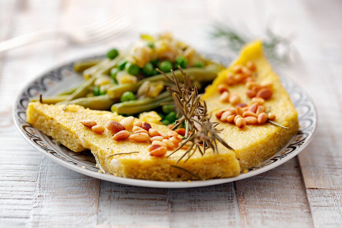 Polenta slices with pine nuts and beans