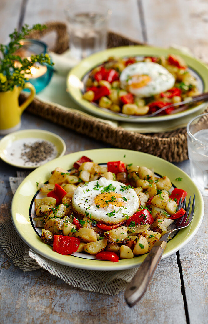 Fried potatoes with fried eggs and cherry tomatoes