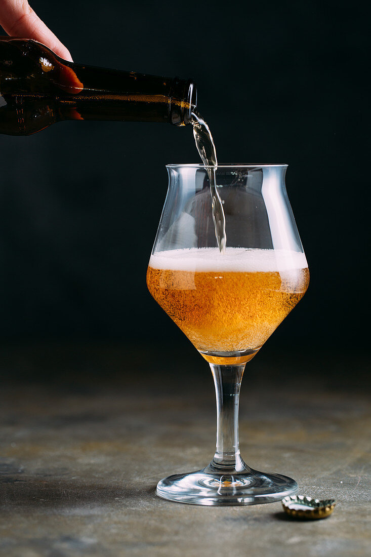 Beer being poured from a bottle into a beer glass