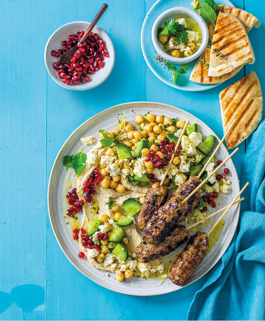 Turkish lamb kofta with hummus, chickpeas, cucumber, feta, and pomegranate seeds