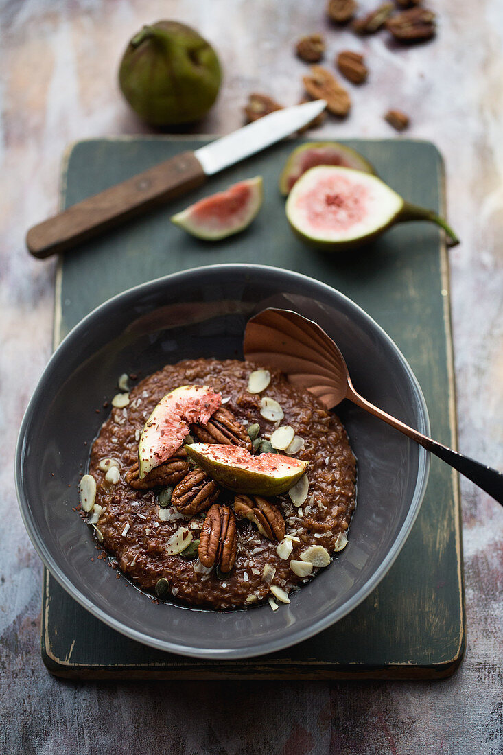 Porridge mit Kakao, Feigen, Mandeln, Ahornsirup und Pecannüssen