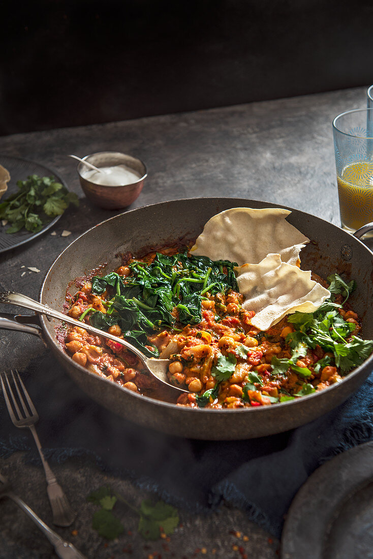 Vegeterian chickpea and spinach curry with coriander and poppadoms