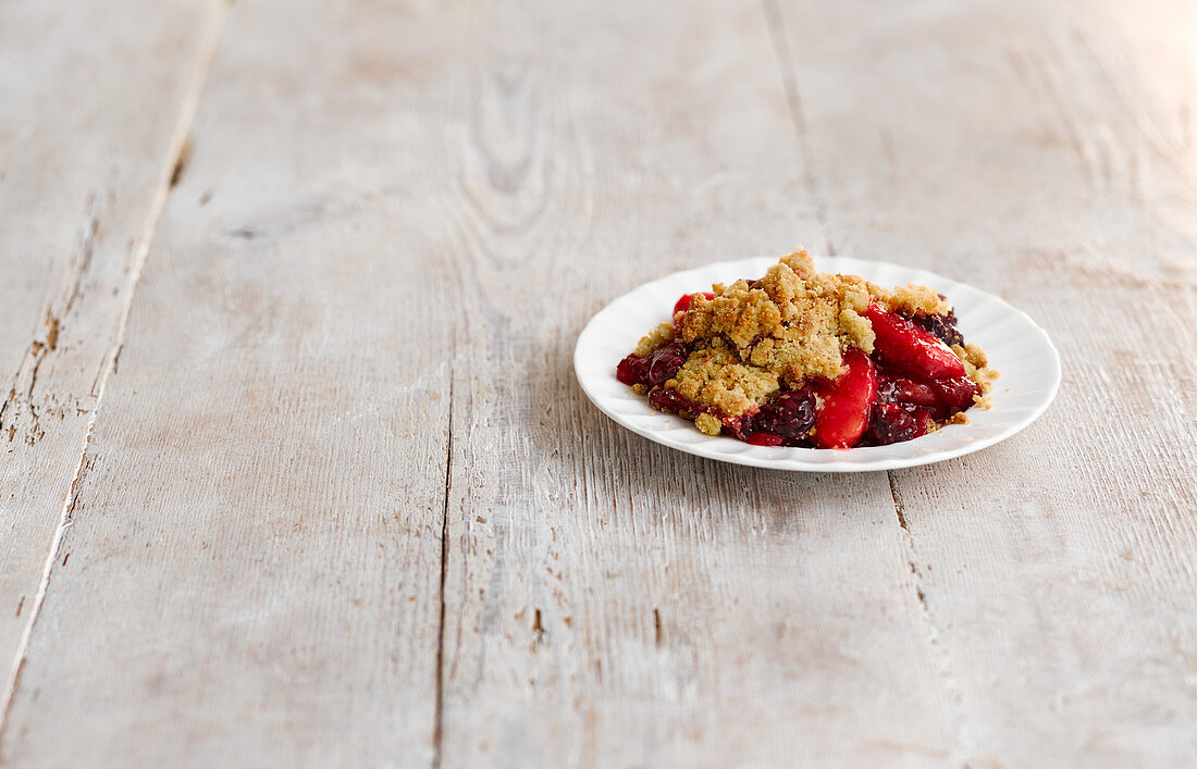 Apple and blackberry crumble on a plate
